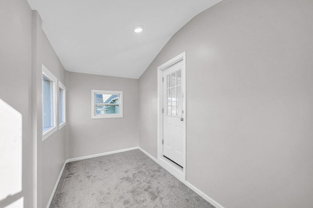 carpeted spare room with lofted ceiling