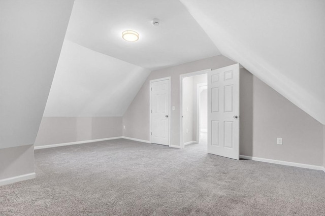 additional living space featuring carpet flooring and vaulted ceiling