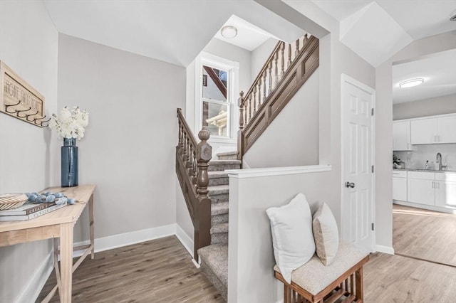 stairway featuring wood-type flooring and sink