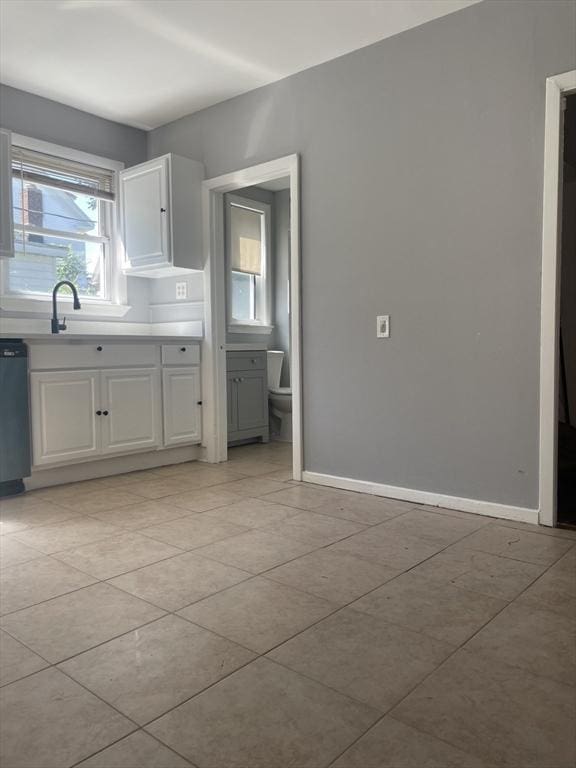 38 Chatham St, Lynn, MA 01902 - kitchen with dishwasher, white cabinets, light countertops, and light tile patterned floors