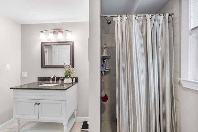 full bathroom featuring vanity, baseboards, and a tile shower