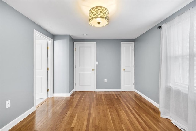 unfurnished bedroom featuring baseboards and hardwood / wood-style floors