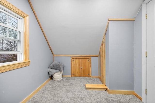 staircase featuring baseboards, carpet floors, and lofted ceiling