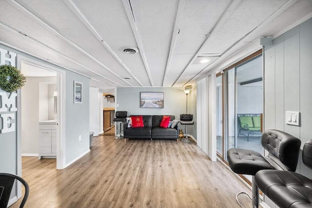 living area featuring visible vents, baseboards, and light wood finished floors