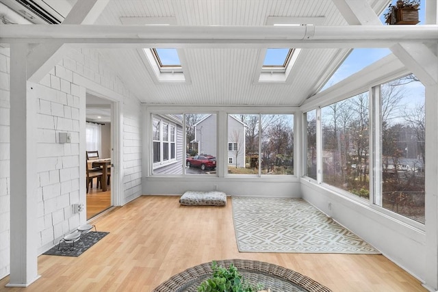 sunroom featuring lofted ceiling with skylight