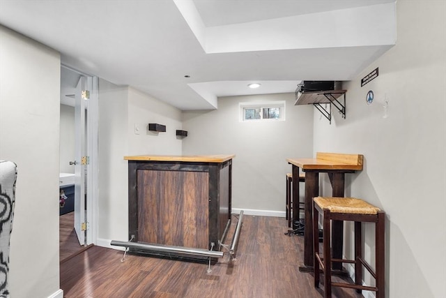 bar featuring dark wood finished floors, visible vents, and baseboards