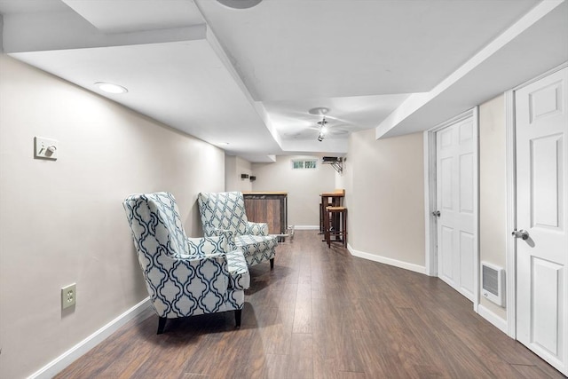 living area featuring visible vents, baseboards, and wood finished floors