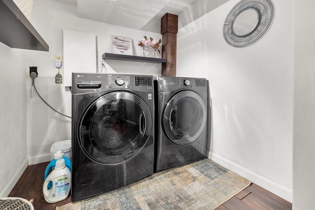 laundry room with baseboards, separate washer and dryer, wood finished floors, and laundry area