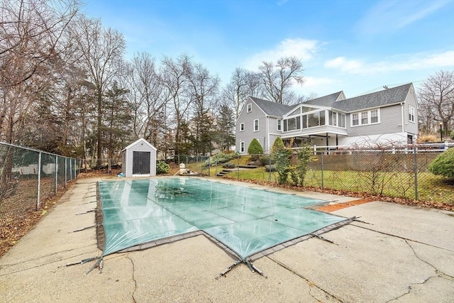 view of swimming pool with an outbuilding, a fenced in pool, a storage unit, and a fenced backyard