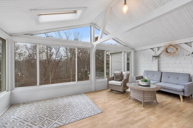 sunroom featuring lofted ceiling with skylight