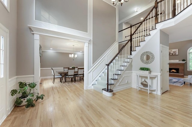 138 Fairview St, Holliston, MA 01746 - foyer featuring a towering ceiling, a chandelier, stairs, wood finished floors, and a decorative wall