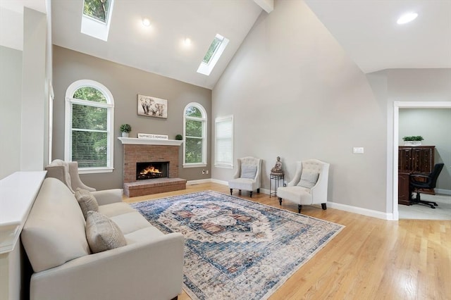 138 Fairview St, Holliston, MA 01746 - living area featuring a skylight, high vaulted ceiling, light wood-type flooring, a brick fireplace, and recessed lighting