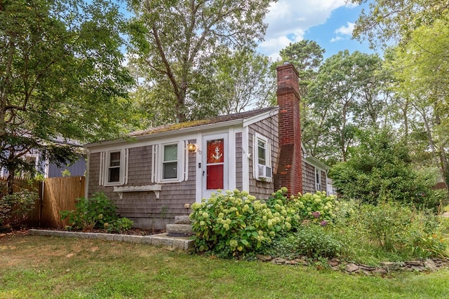 view of front of home with a front yard and cooling unit