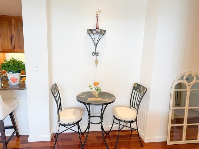 dining area with dark wood-style floors and baseboards