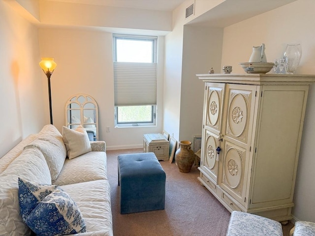 living area with light carpet, healthy amount of natural light, and baseboards