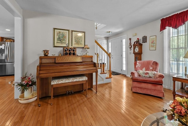 sitting room featuring stairs and light wood-style floors