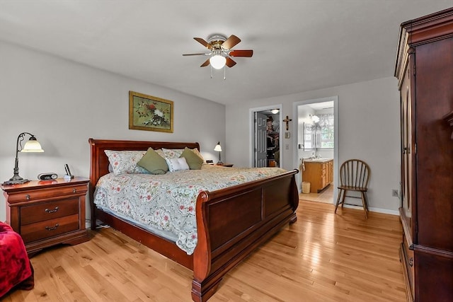 bedroom featuring a sink, a spacious closet, a ceiling fan, and light wood-style floors