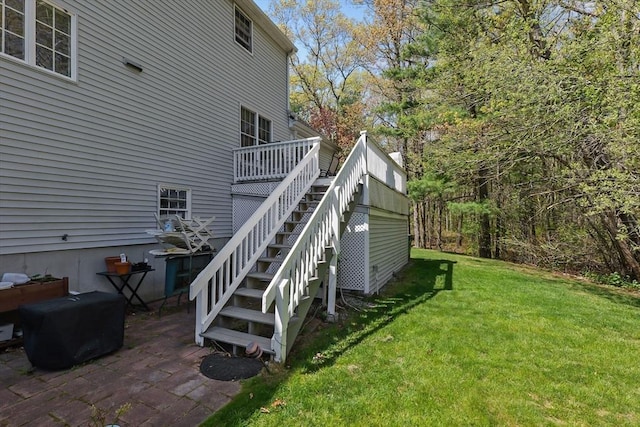 view of property exterior featuring a yard, stairway, and a deck