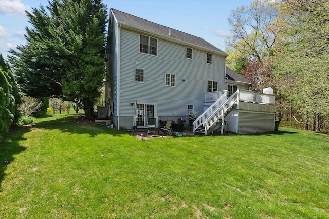 back of house featuring stairs, a patio, a deck, and a lawn