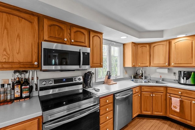 kitchen featuring recessed lighting, light countertops, appliances with stainless steel finishes, and a sink
