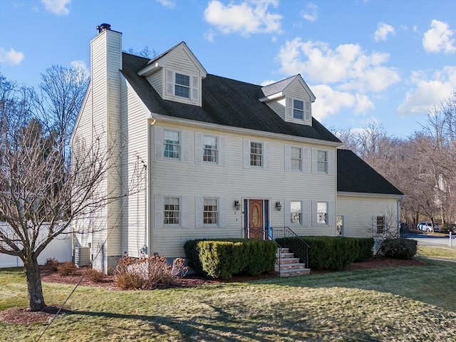 view of front of property with central AC unit and a front lawn