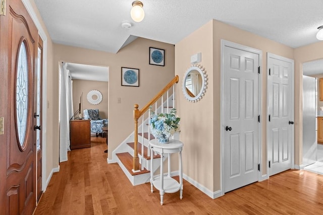 entrance foyer featuring a textured ceiling and light hardwood / wood-style flooring