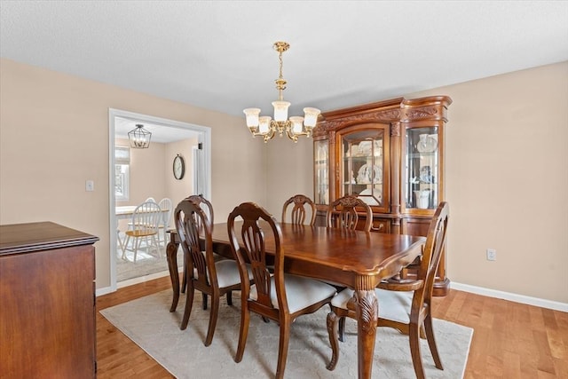 dining room with a chandelier and light wood-type flooring