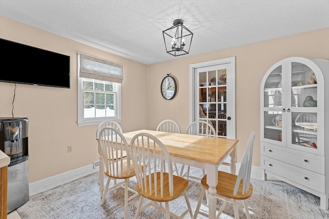 dining space with a chandelier and a textured ceiling