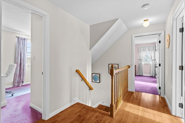 hallway featuring a textured ceiling and light wood-type flooring