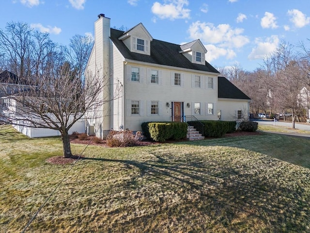 view of front of home with central AC and a front lawn