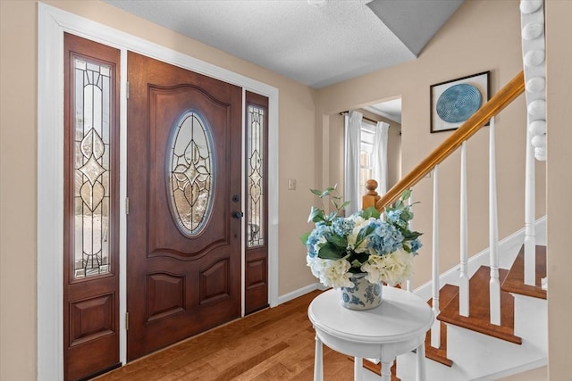 foyer with light hardwood / wood-style floors and a textured ceiling