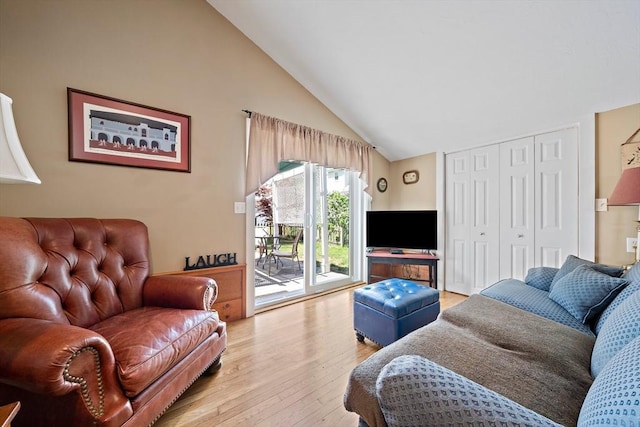 living room with light wood-style flooring and high vaulted ceiling