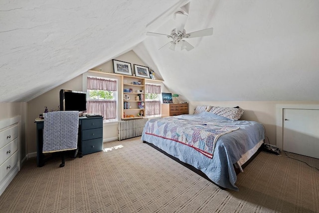 bedroom with carpet flooring, vaulted ceiling, ceiling fan, and radiator heating unit
