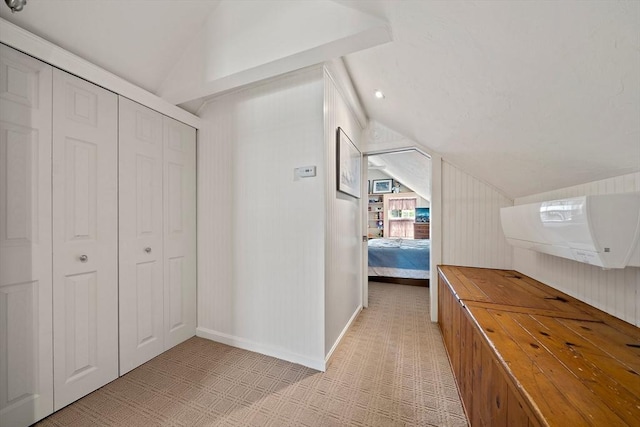 hallway with baseboards, light colored carpet, and vaulted ceiling