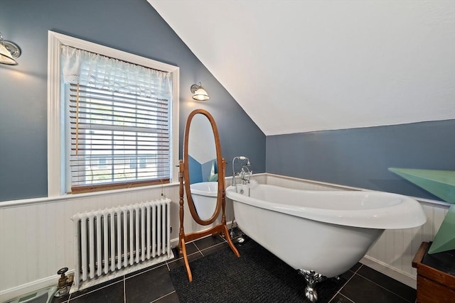 bathroom with radiator, tile patterned floors, plenty of natural light, and vaulted ceiling