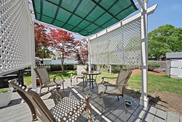 wooden deck with an outdoor structure, a shed, a pergola, and a fenced backyard