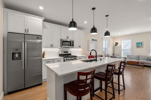 9-11 Dexter, Boston, MA 02127 - kitchen featuring stainless steel appliances, a sink, light wood-type flooring, an island with sink, and backsplash