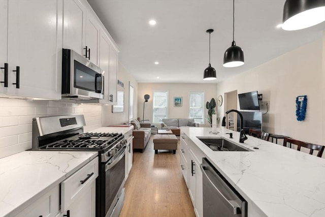 9-11 Dexter, Boston, MA 02127 - kitchen with stainless steel appliances, a sink, open floor plan, light wood-style floors, and decorative backsplash