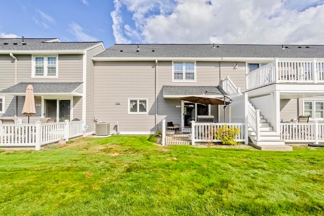 rear view of property with a wooden deck, a yard, and central air condition unit