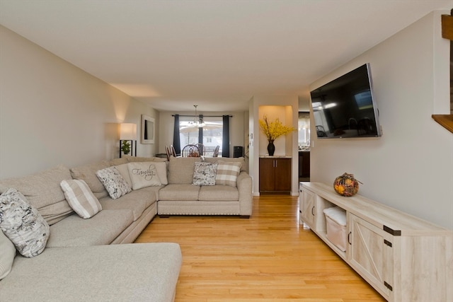 living room with light hardwood / wood-style flooring and an inviting chandelier