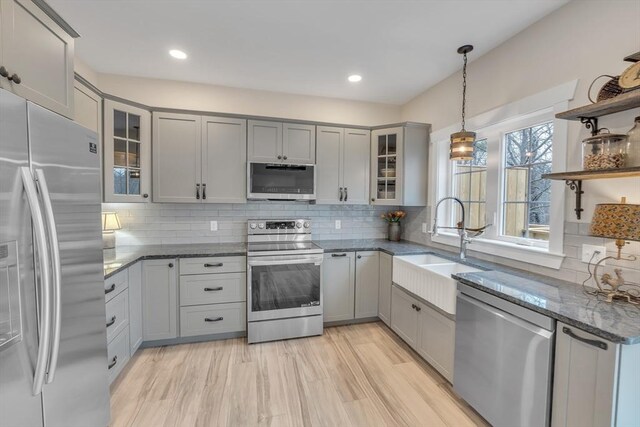 260 Main St Unit 12, Blackstone, MA 01504 - kitchen with stainless steel appliances, gray cabinetry, a sink, dark stone counters, and open shelves