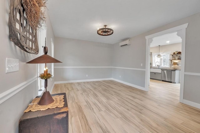 260 Main St Unit 12, Blackstone, MA 01504 - empty room featuring a wall unit AC, light wood-style flooring, baseboards, and a sink