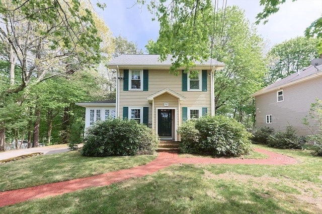 colonial house featuring a front lawn