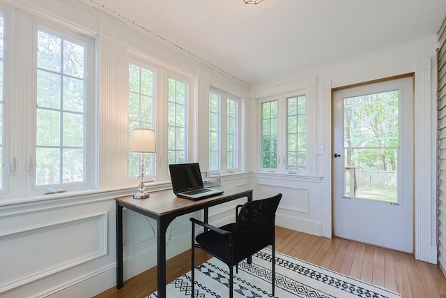 office space featuring light wood-type flooring and a decorative wall