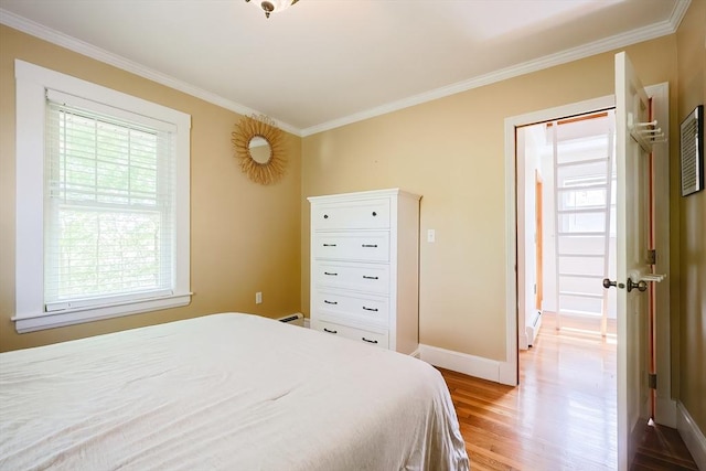 bedroom featuring baseboards, ornamental molding, light wood-style flooring, and a baseboard radiator
