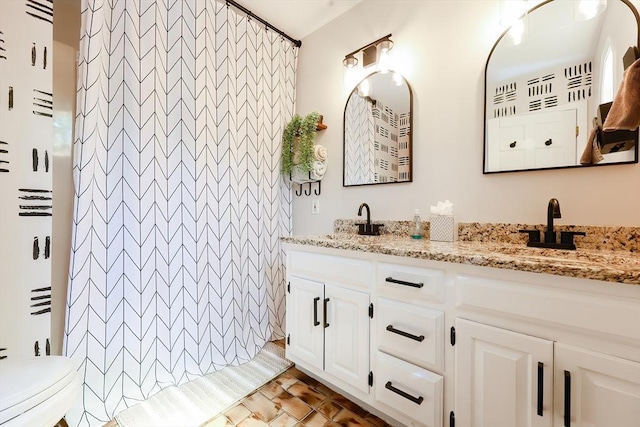 full bathroom with double vanity, a sink, toilet, and a shower with curtain