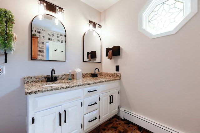 bathroom with a sink, a baseboard radiator, and double vanity