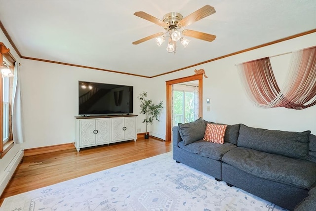 living area with baseboards, ornamental molding, and wood finished floors