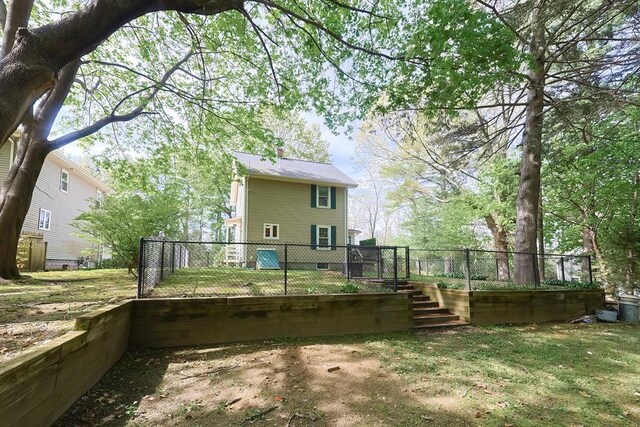 rear view of property featuring a yard and fence private yard