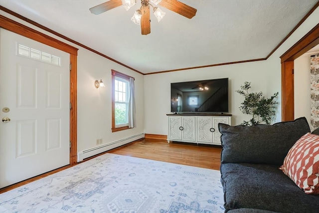 living area with a baseboard radiator, ornamental molding, a ceiling fan, and wood finished floors